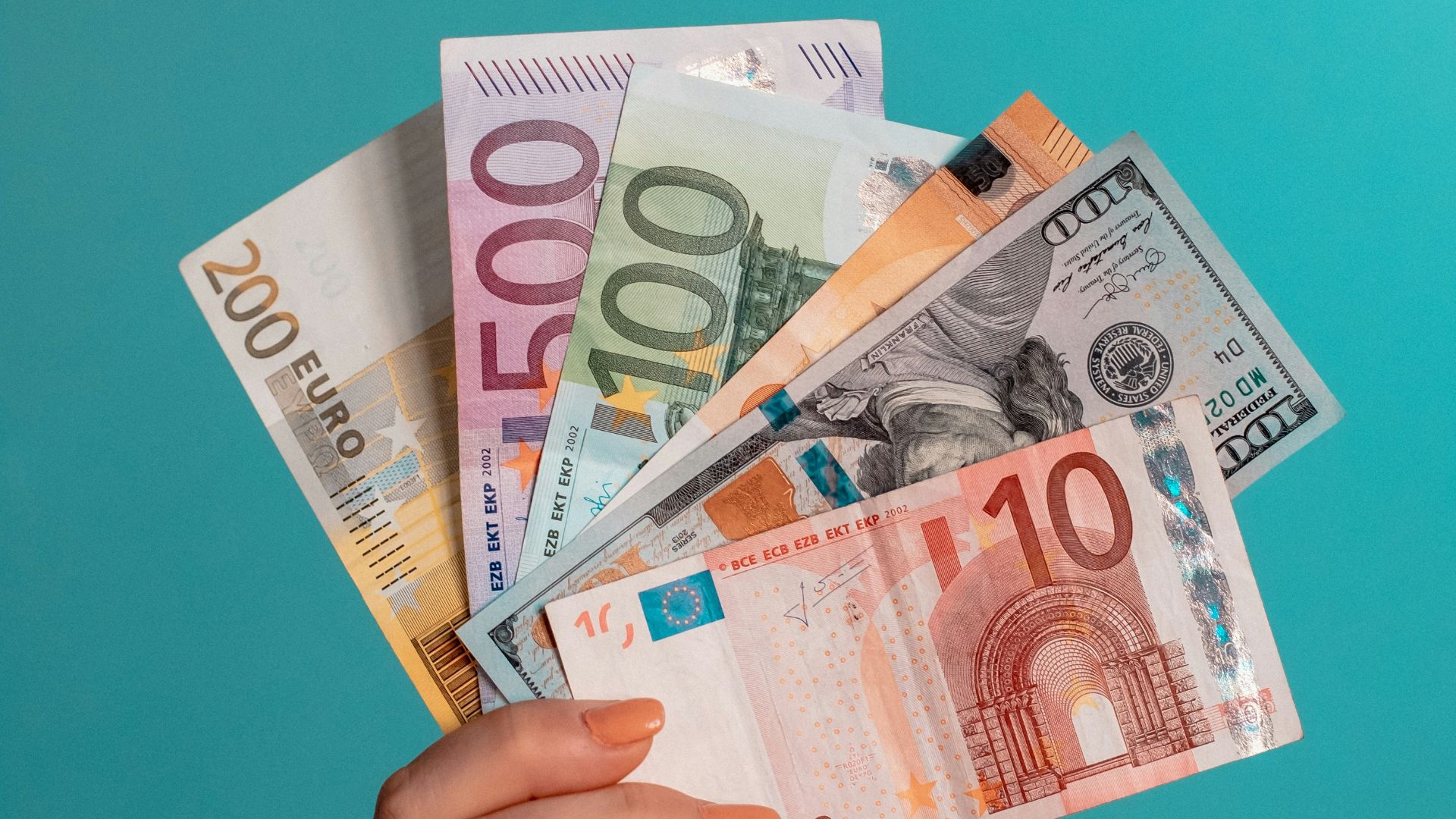 person holding fan of 100 us dollar bill