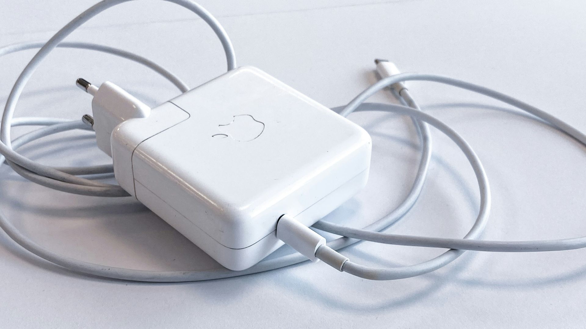 white apple charging adapter on white table