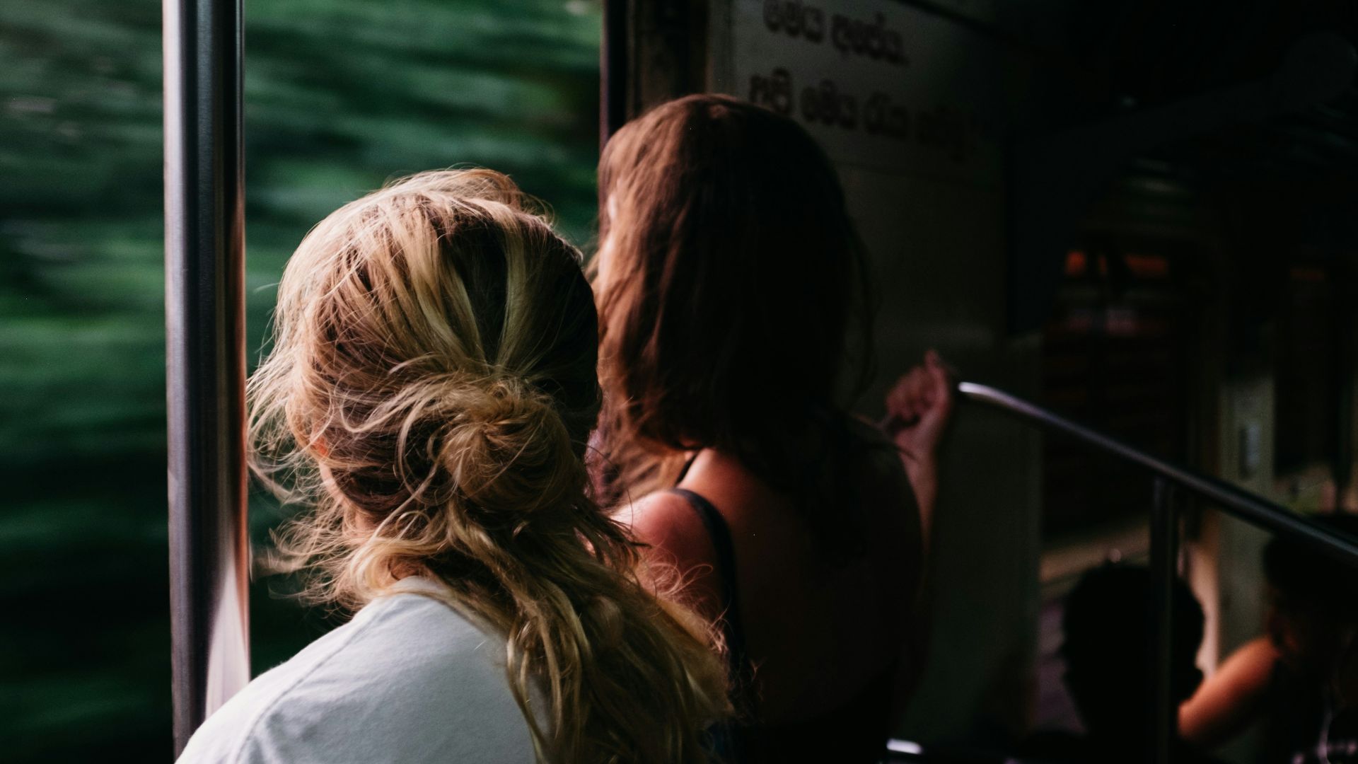 two person standing on train window