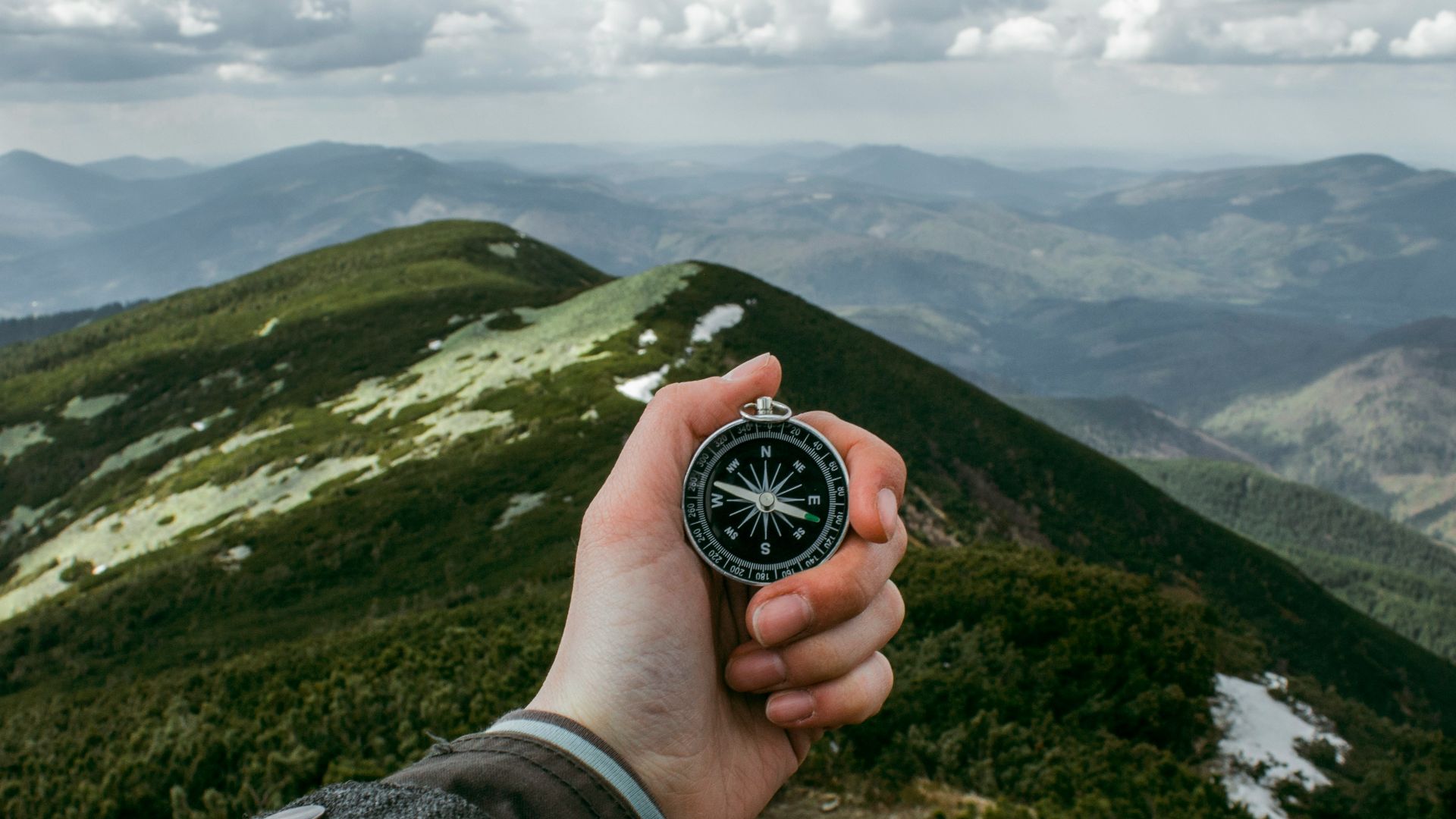 person holding silver compass
