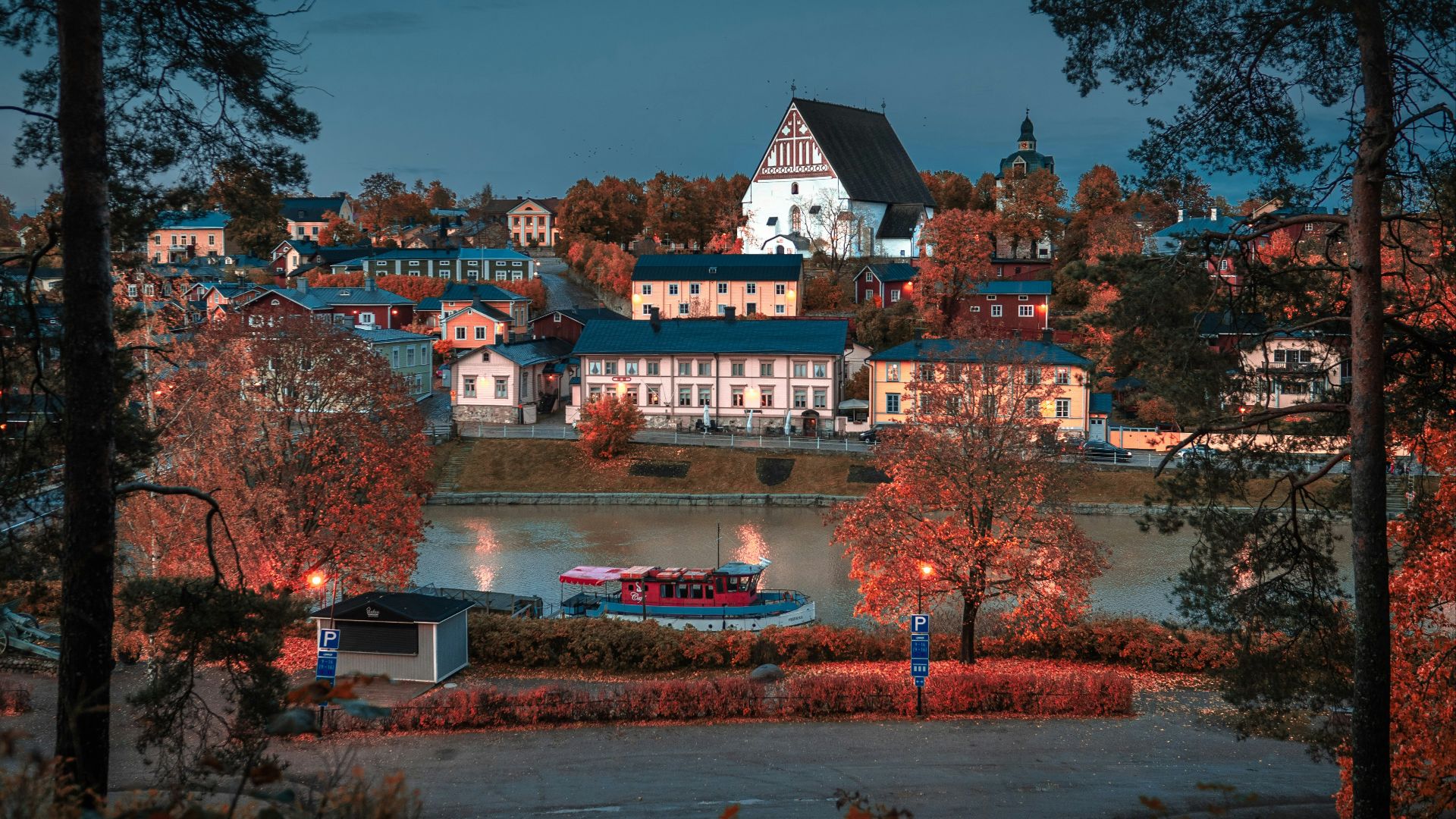 white concrete buildings beside body of water at night