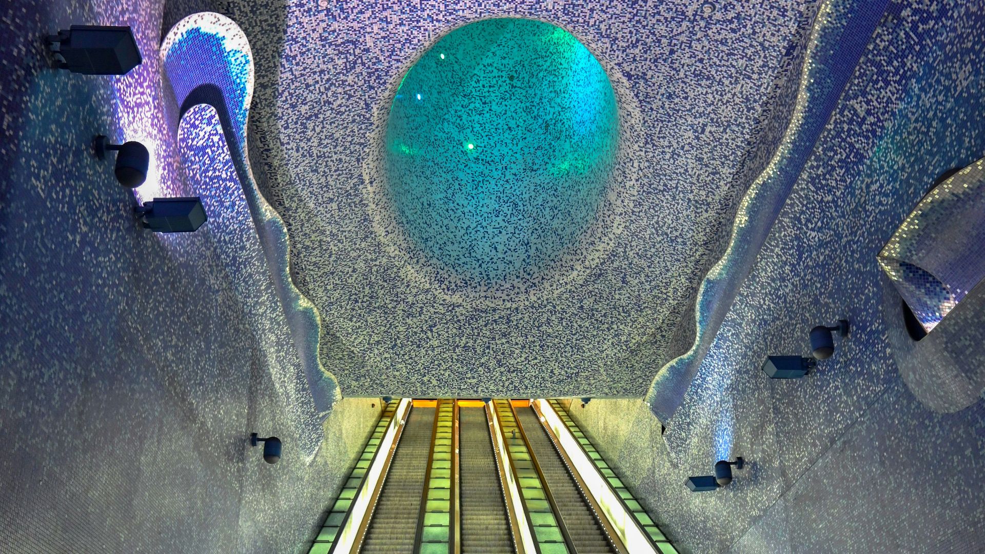 a man and a woman standing at the bottom of an escalator