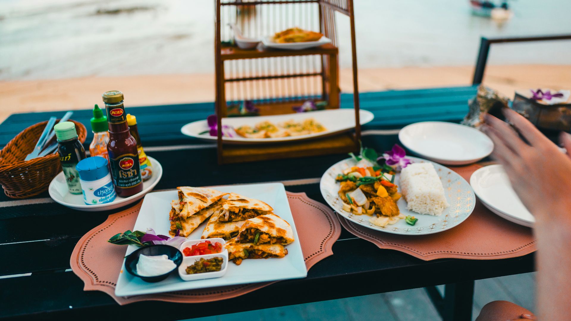 Food and drinks are set for a seaside meal.