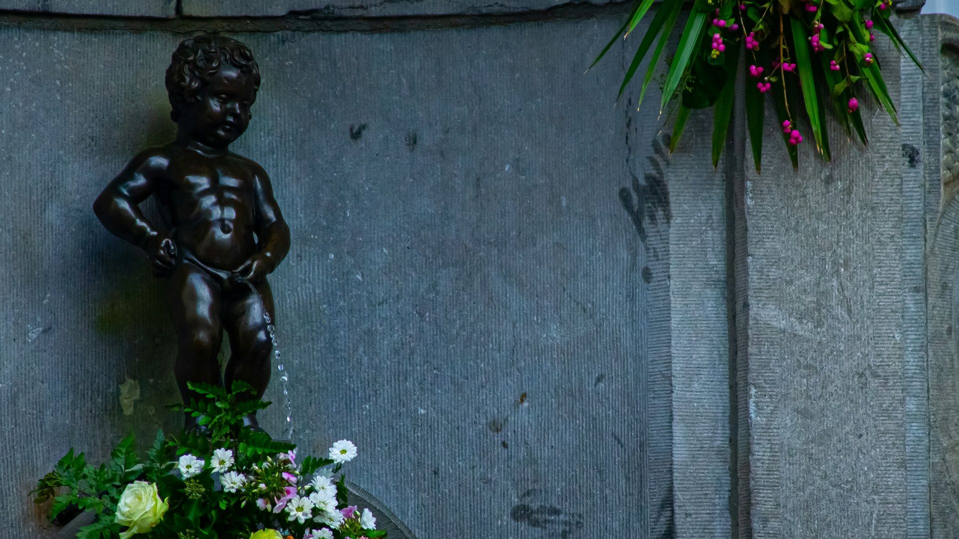 a statue of a boy holding a bouquet of flowers