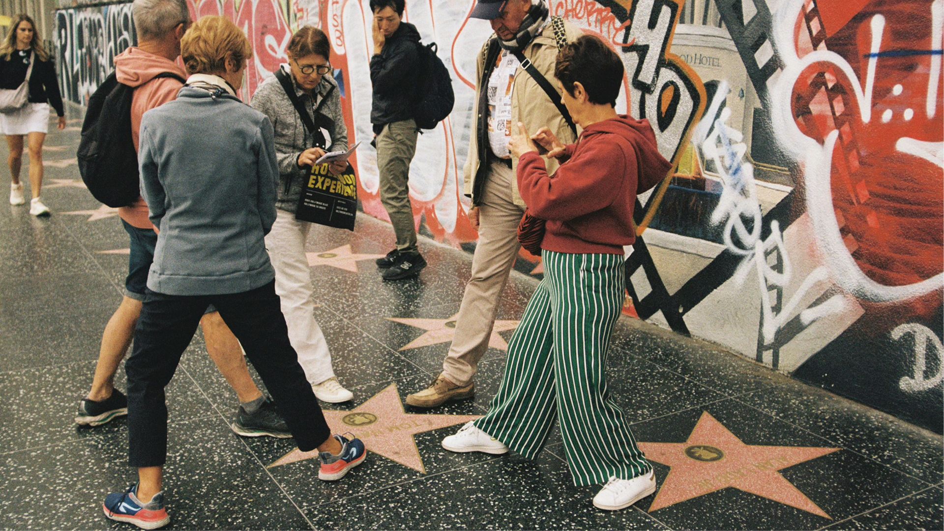 People are walking the hollywood walk of fame.