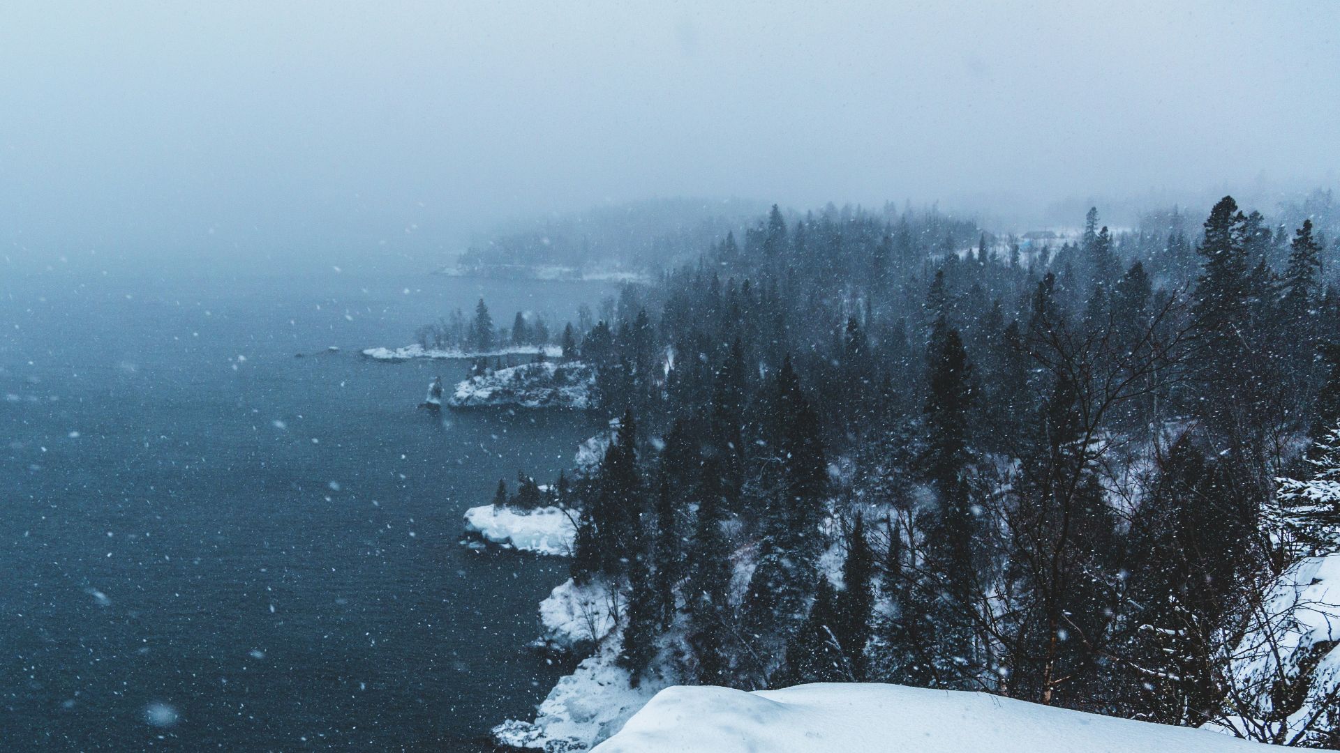 snow covered mountain near body of water during daytime