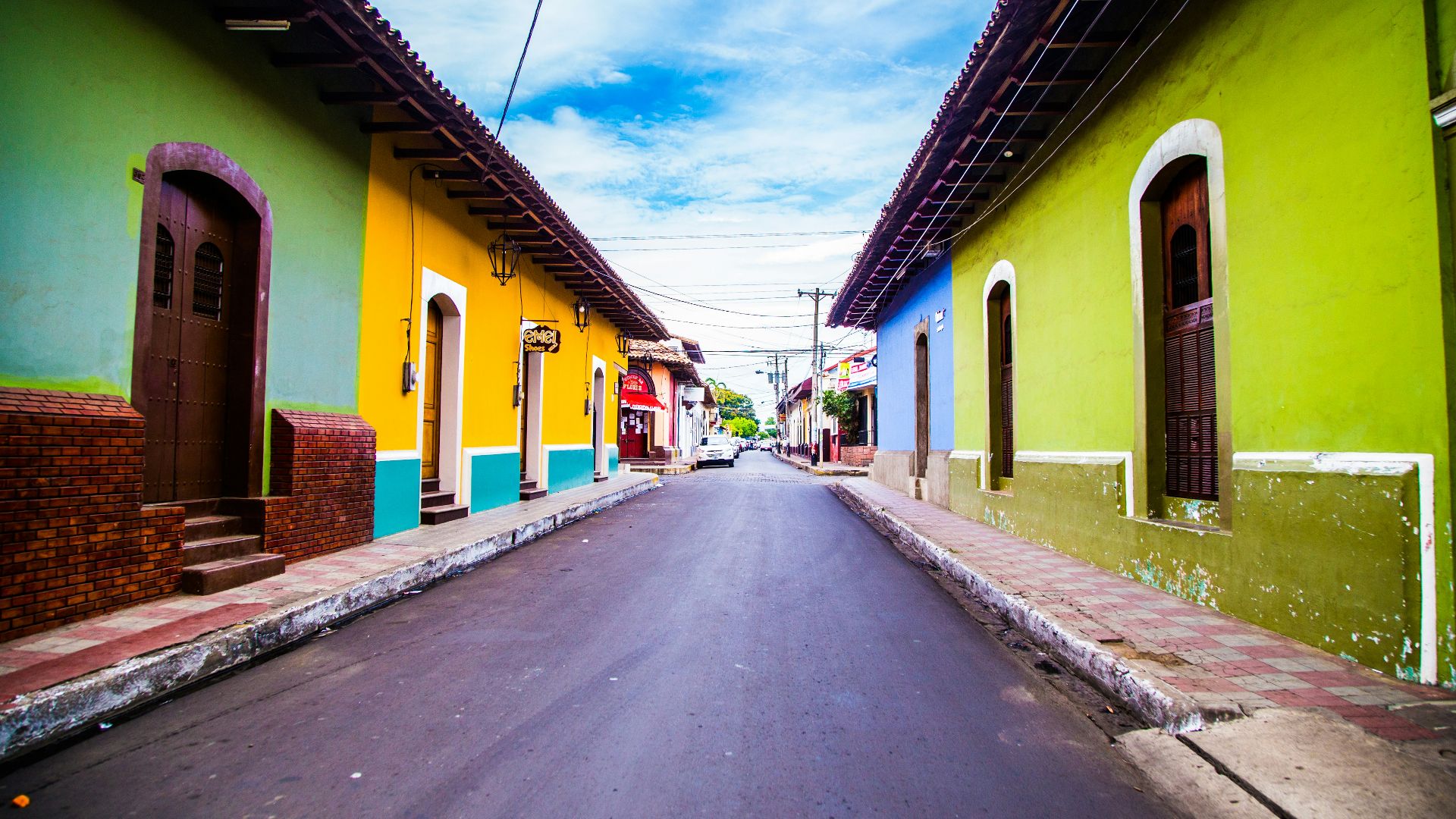 pathway of houses under blue clouds during daytime