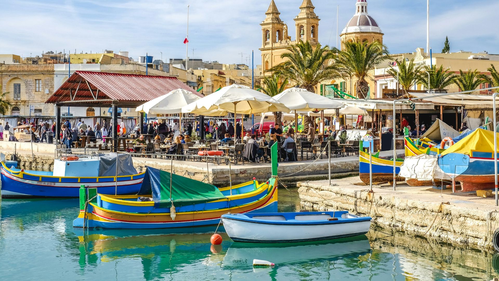 blue and yellow boat on water near brown concrete building during daytime