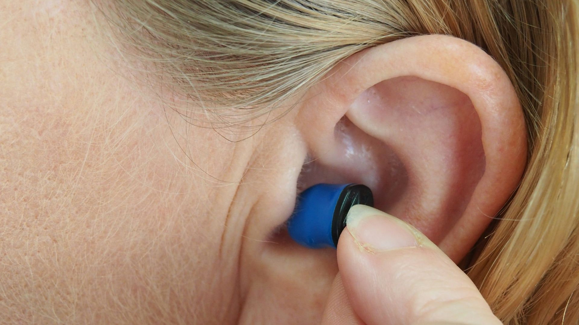 woman wearing blue stud earring