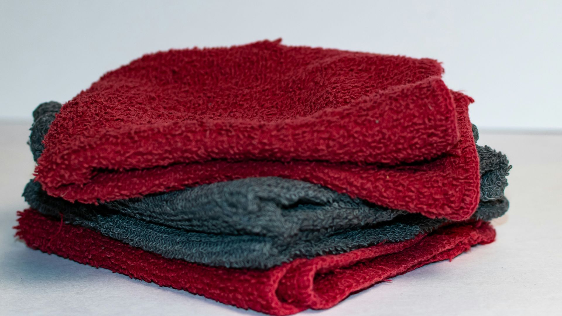 A stack of red and grey towels sitting on top of a table
