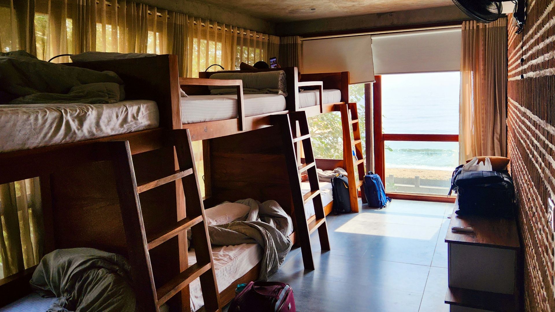 a room filled with lots of bunk beds next to a window