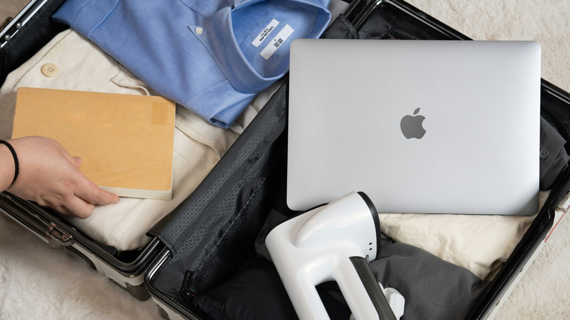 An open suitcase with a laptop and other items