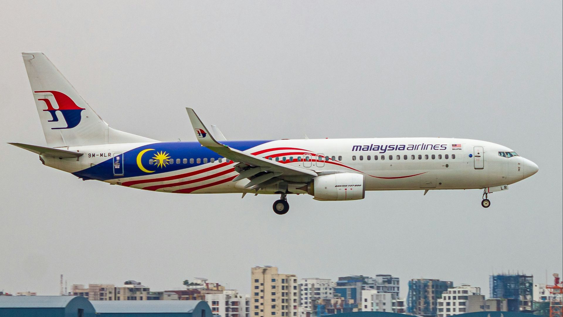 a large jetliner flying through a cloudy sky