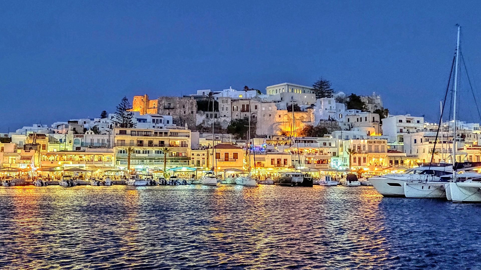 city buildings near body of water during night time