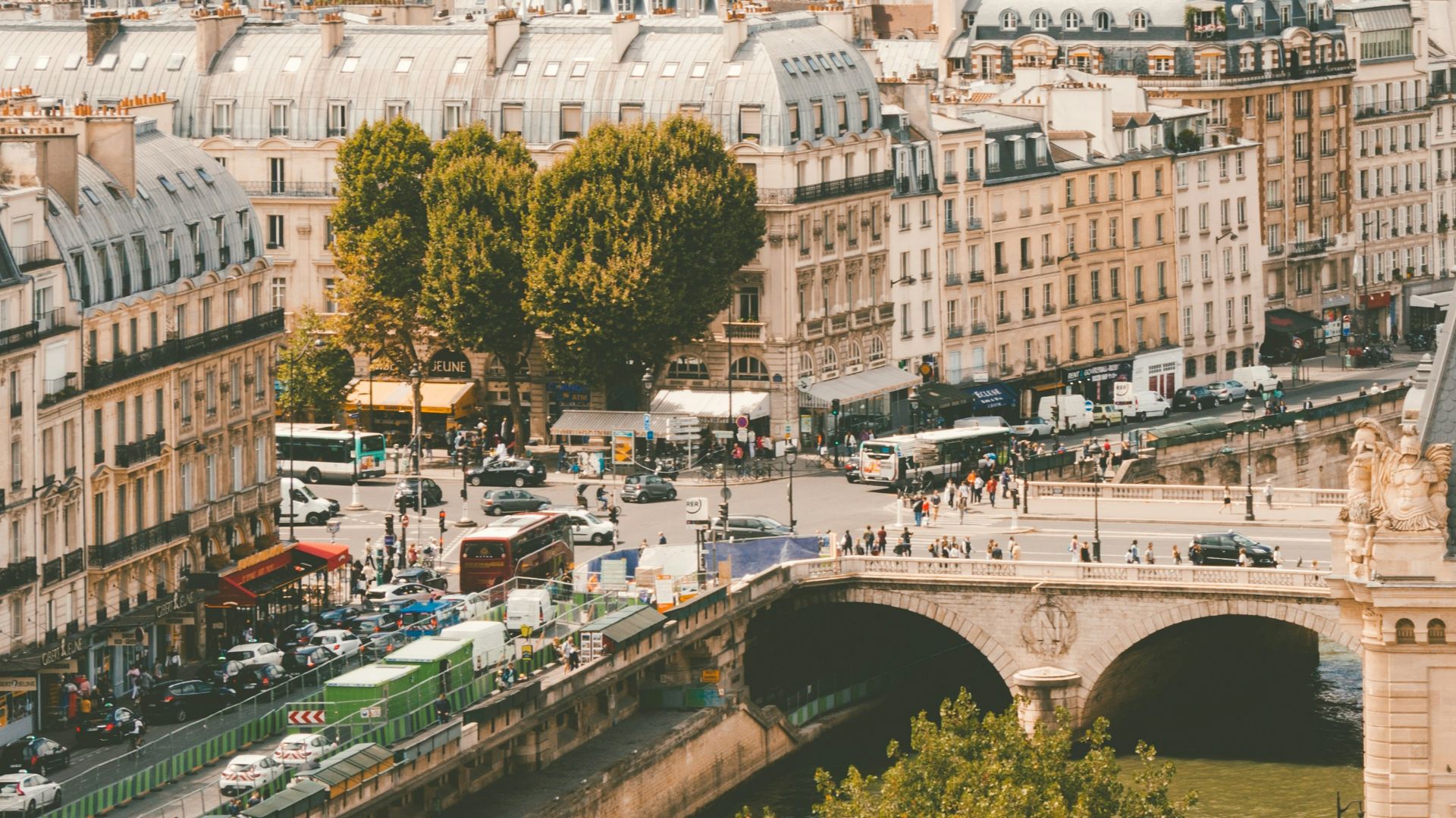 group of people walking near body of water and building under blue sky at daytime