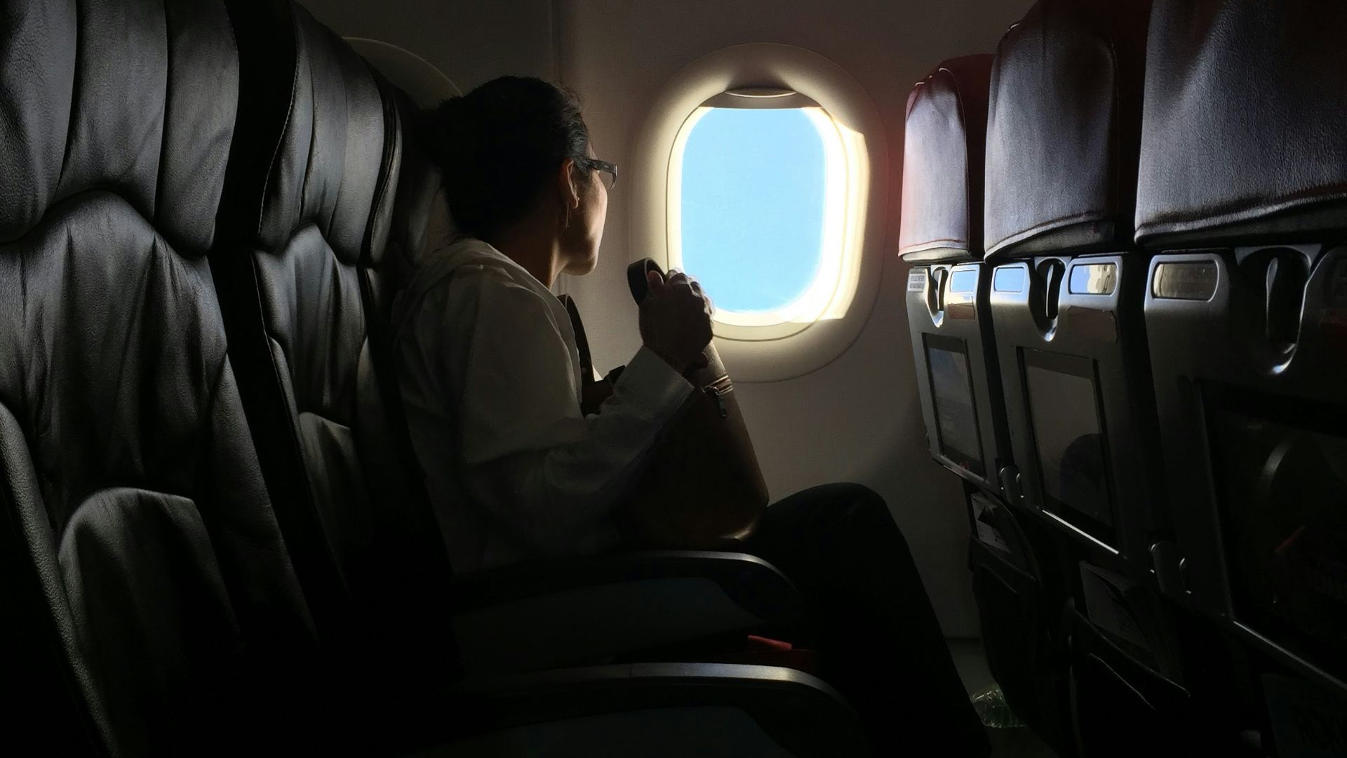 person sitting on plane watching the window