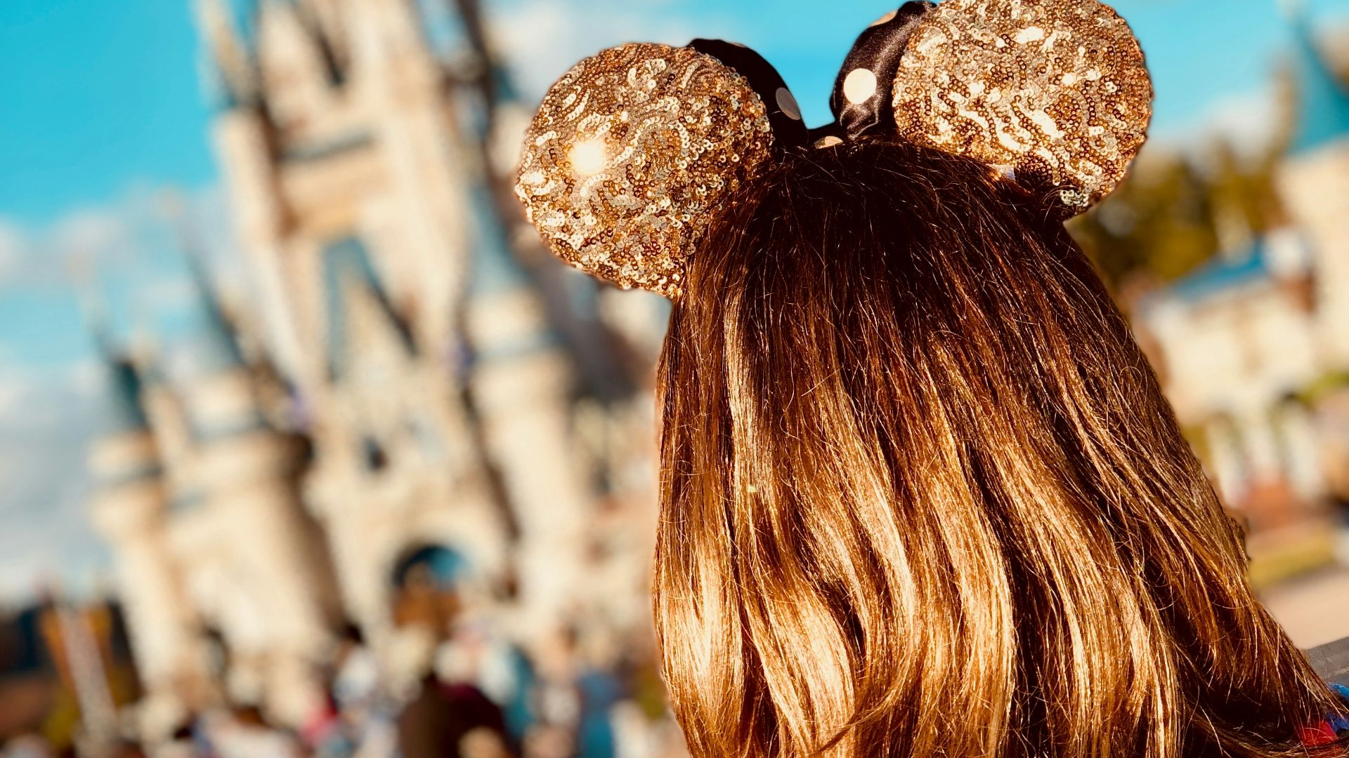 woman wearing golden Mickey Ears at Disneyland