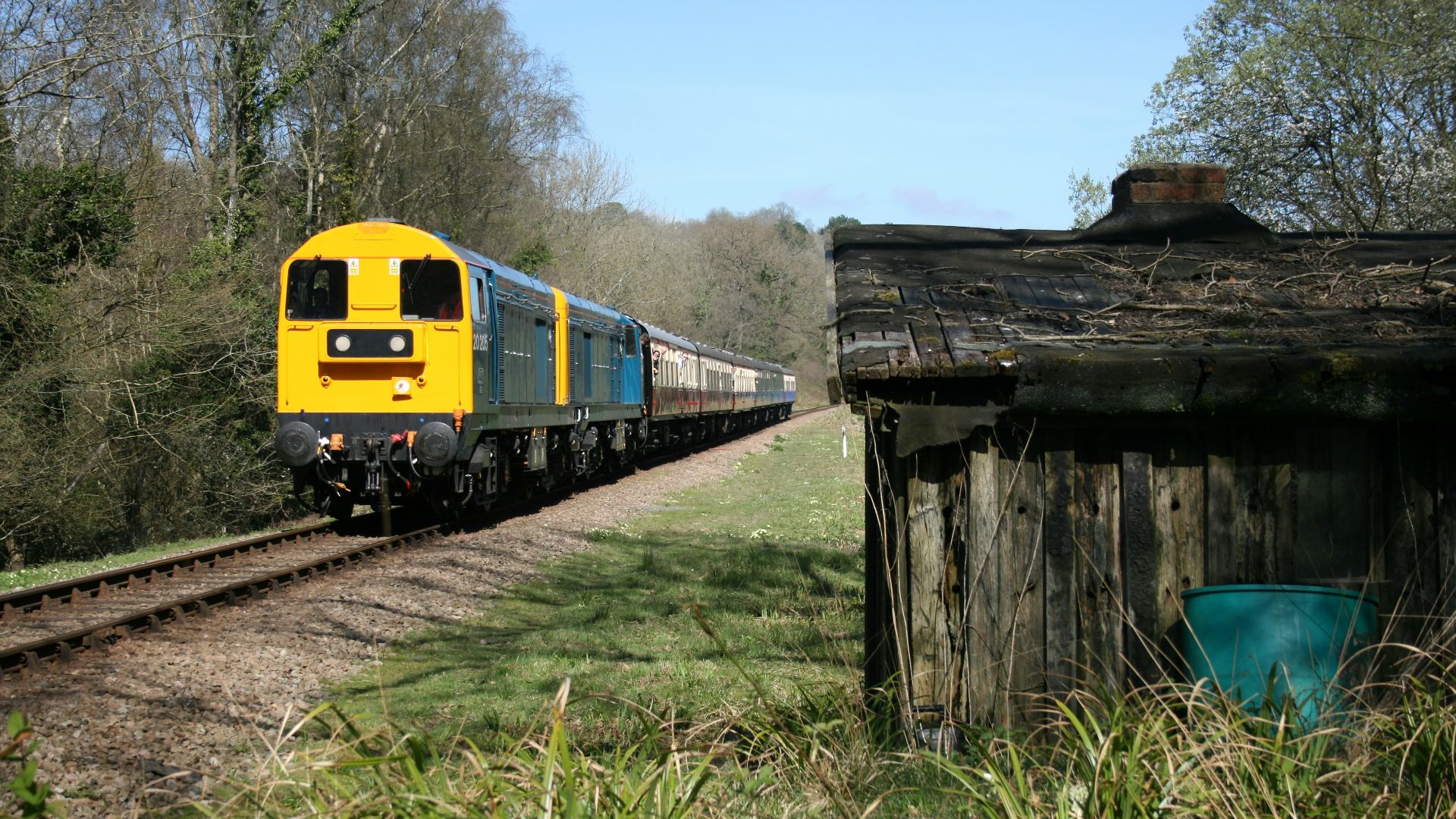 a yellow and blue train traveling down train tracks