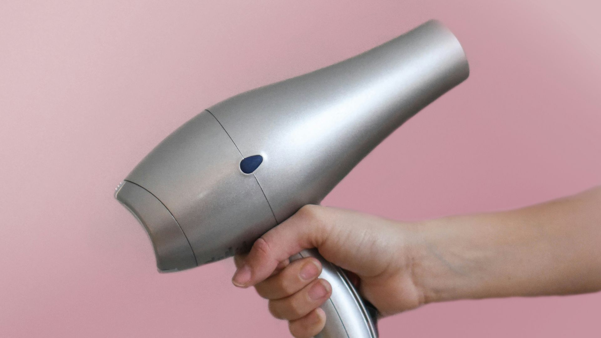 person holding gray corded hair dryer