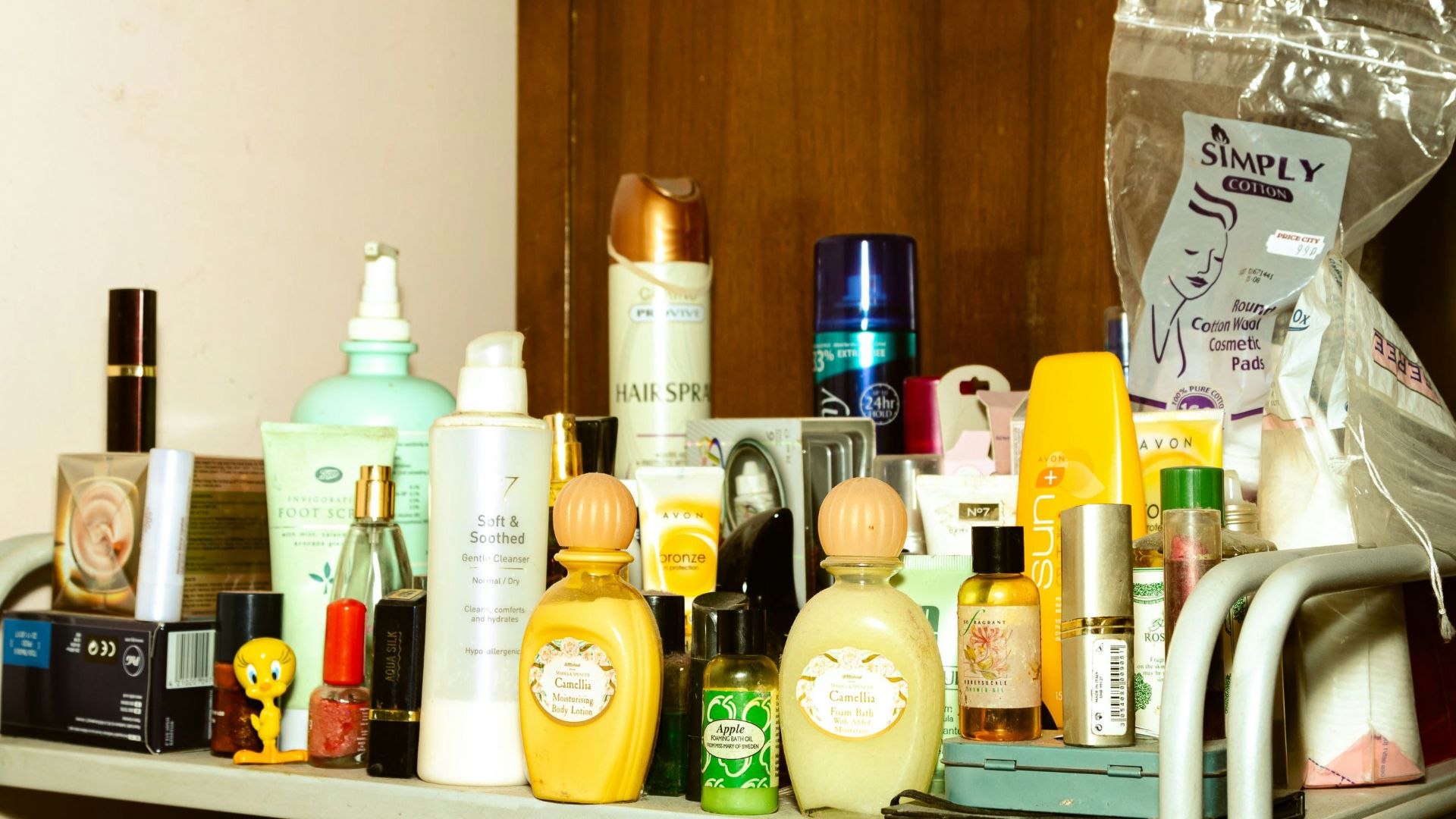 white and yellow plastic bottle on brown wooden shelf