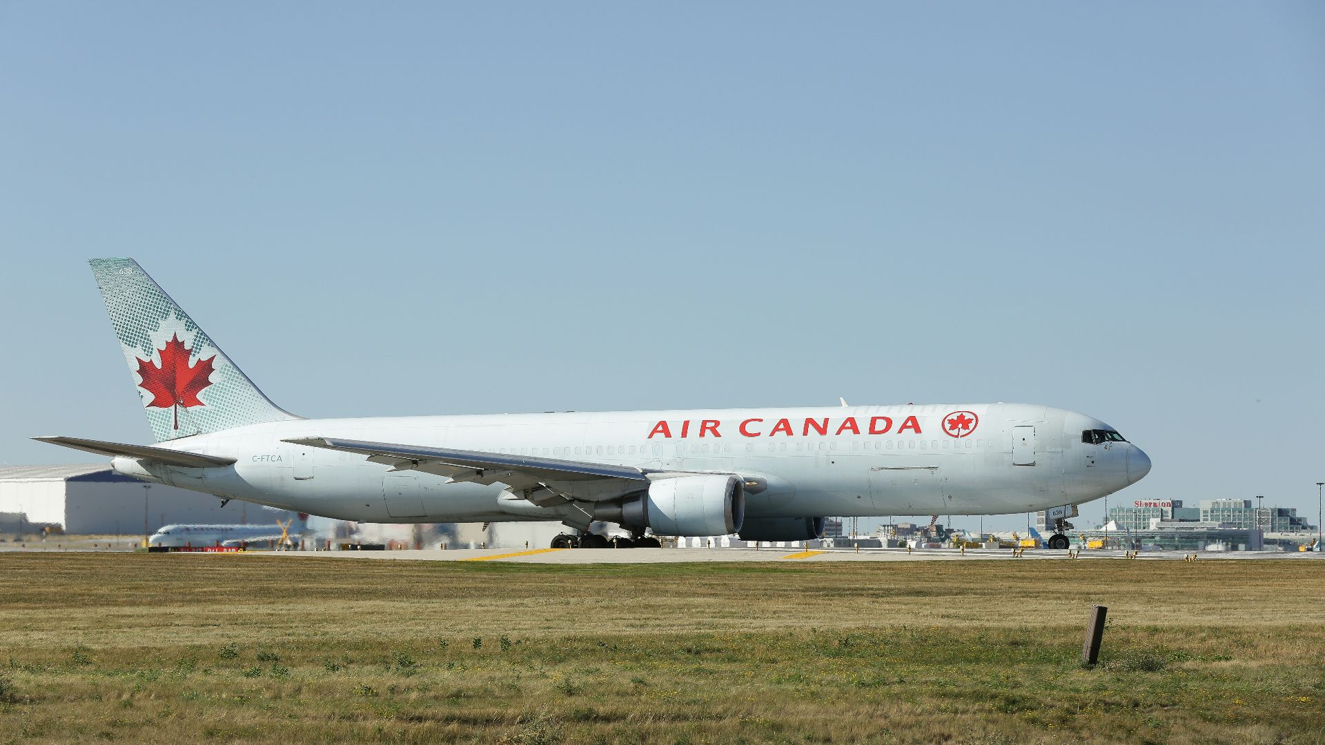 a large air canada jetliner sitting on top of an airport runway