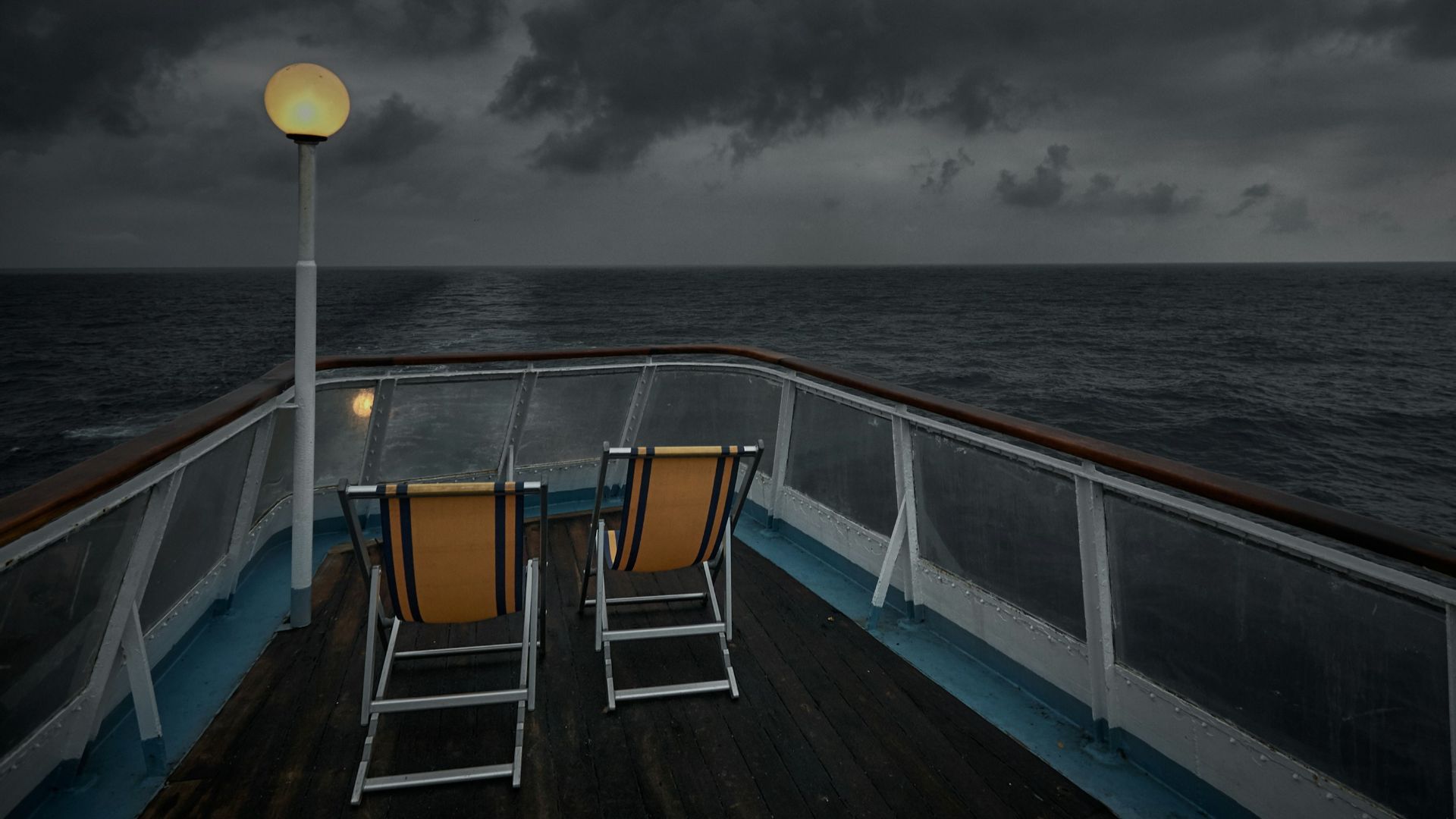 white and yellow boat on sea under gray clouds