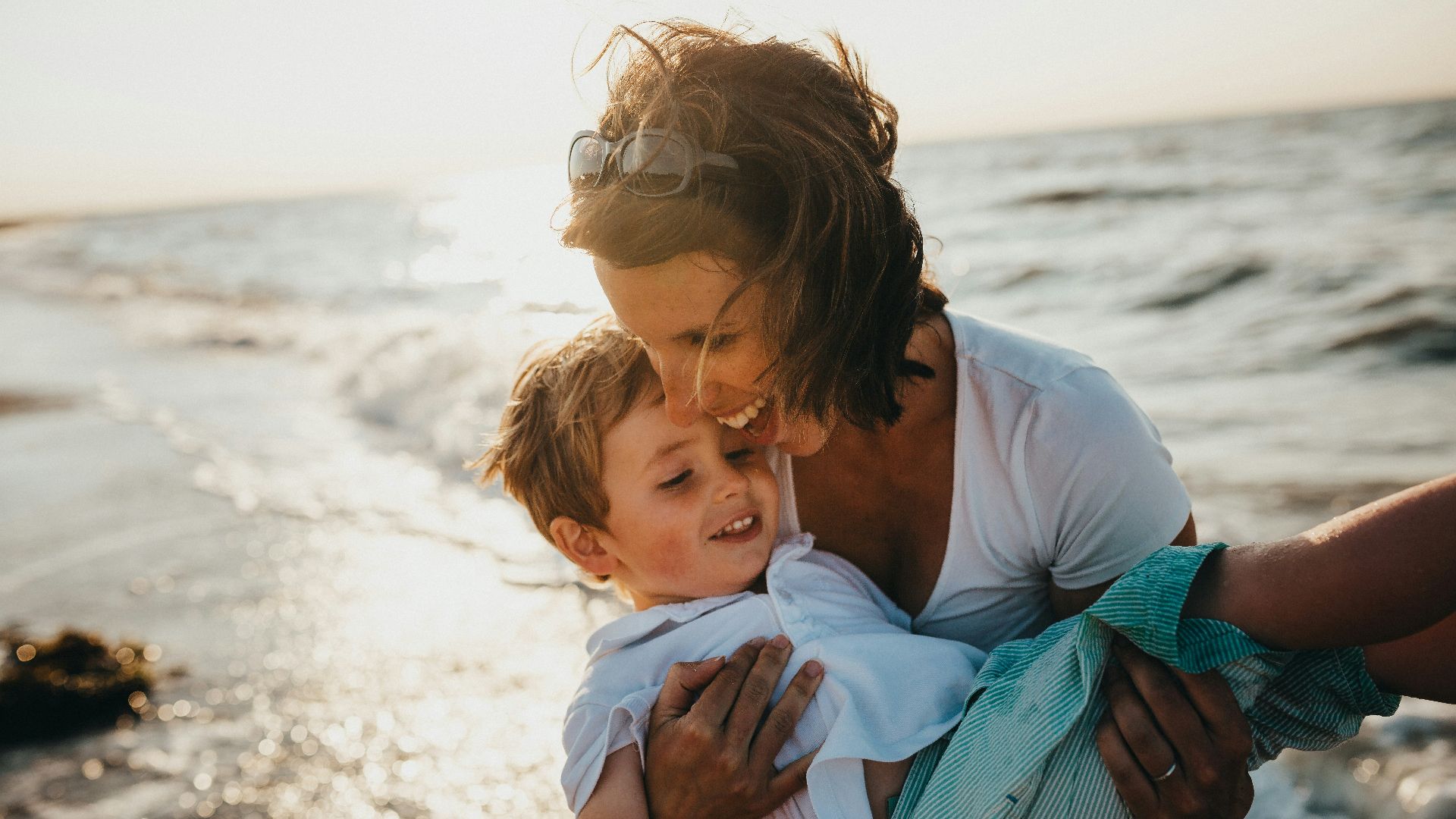 photo of mother and child beside body of water