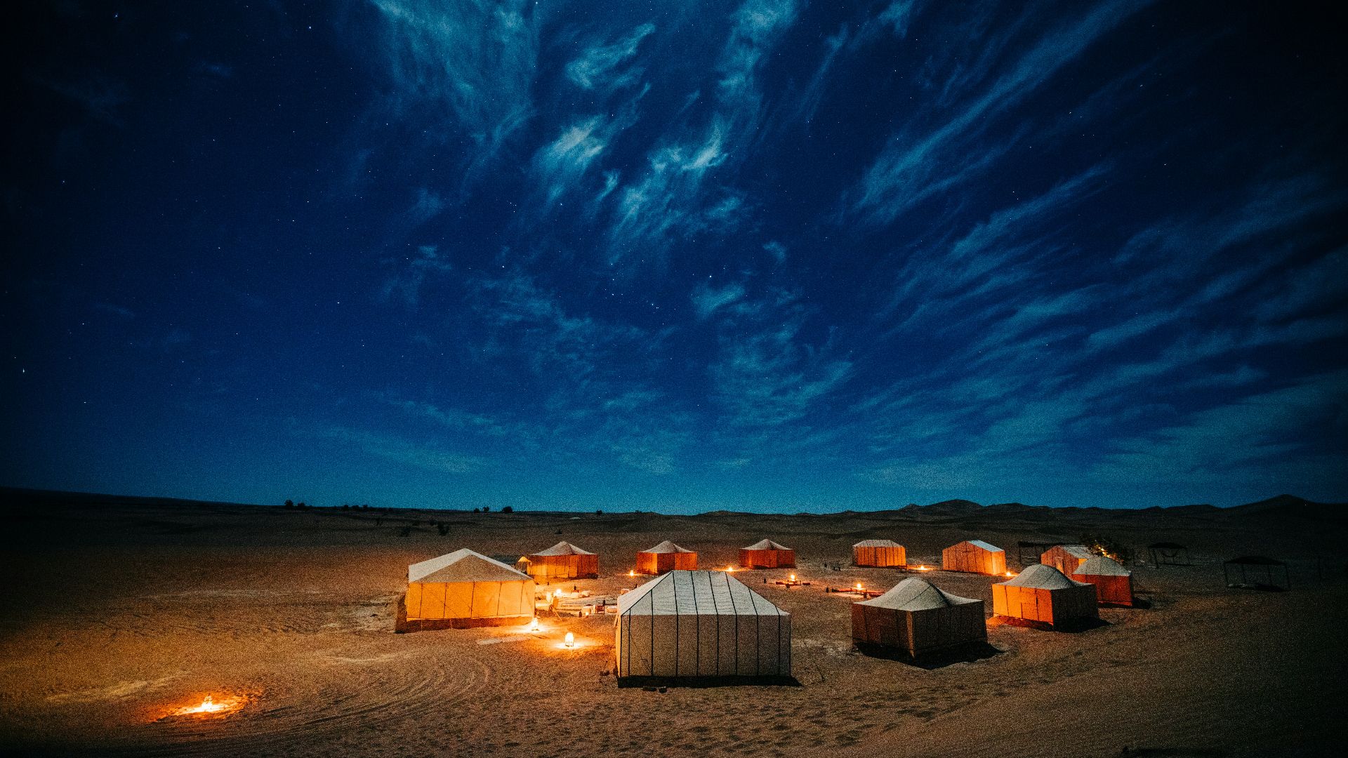 white and brown tent on brown field under blue sky during night time
