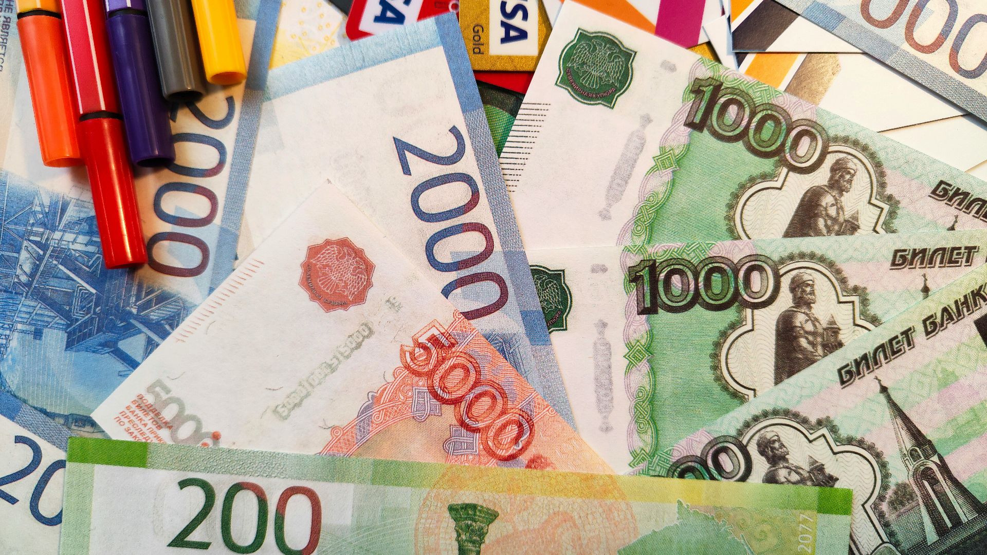 a pile of money with crayons and markers