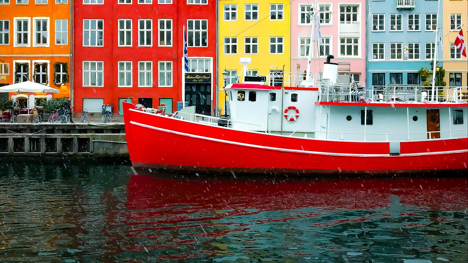 assorted-color buildings near red boat docked on port during daytime