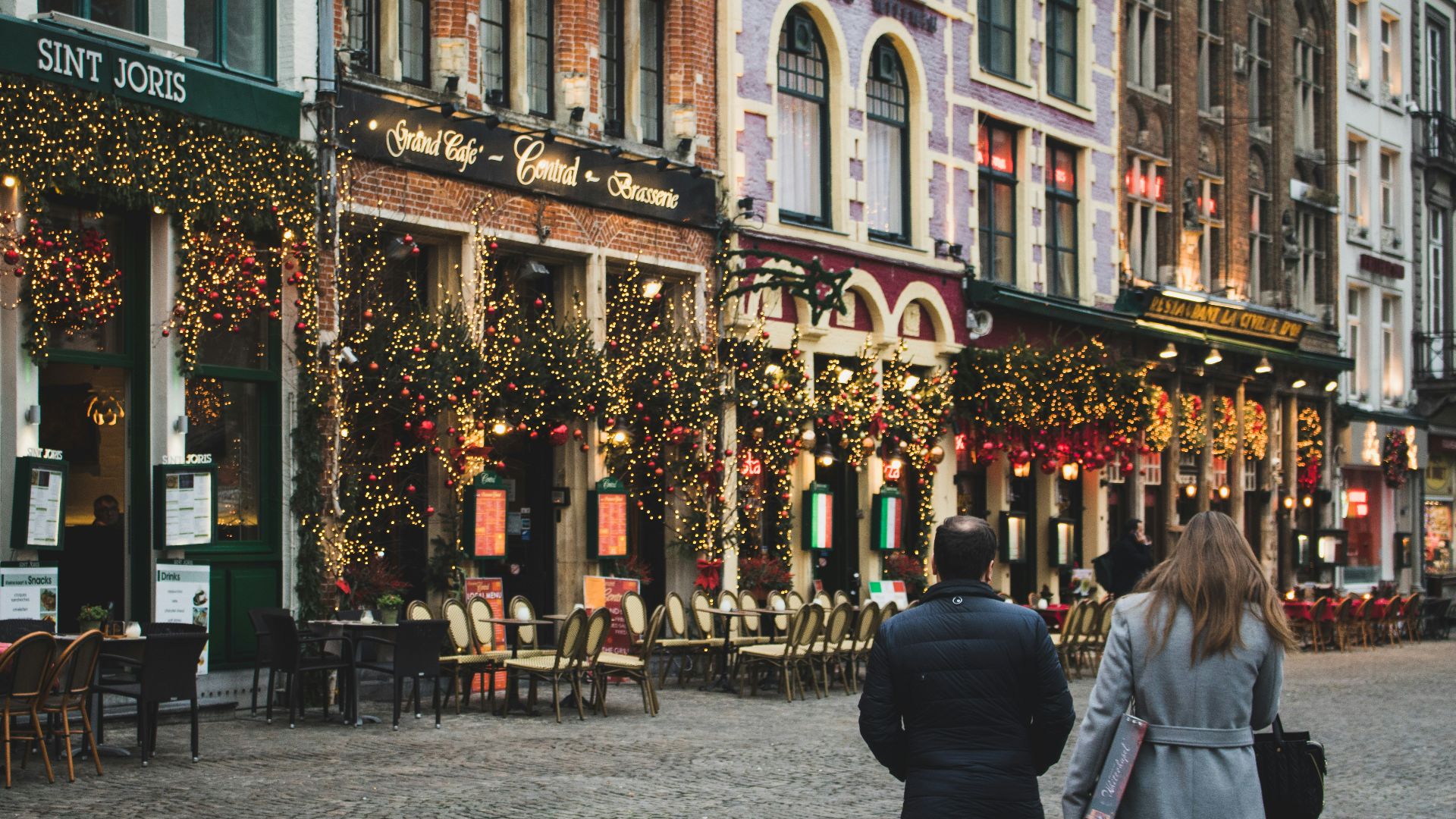 woman and man walking on pavement near building