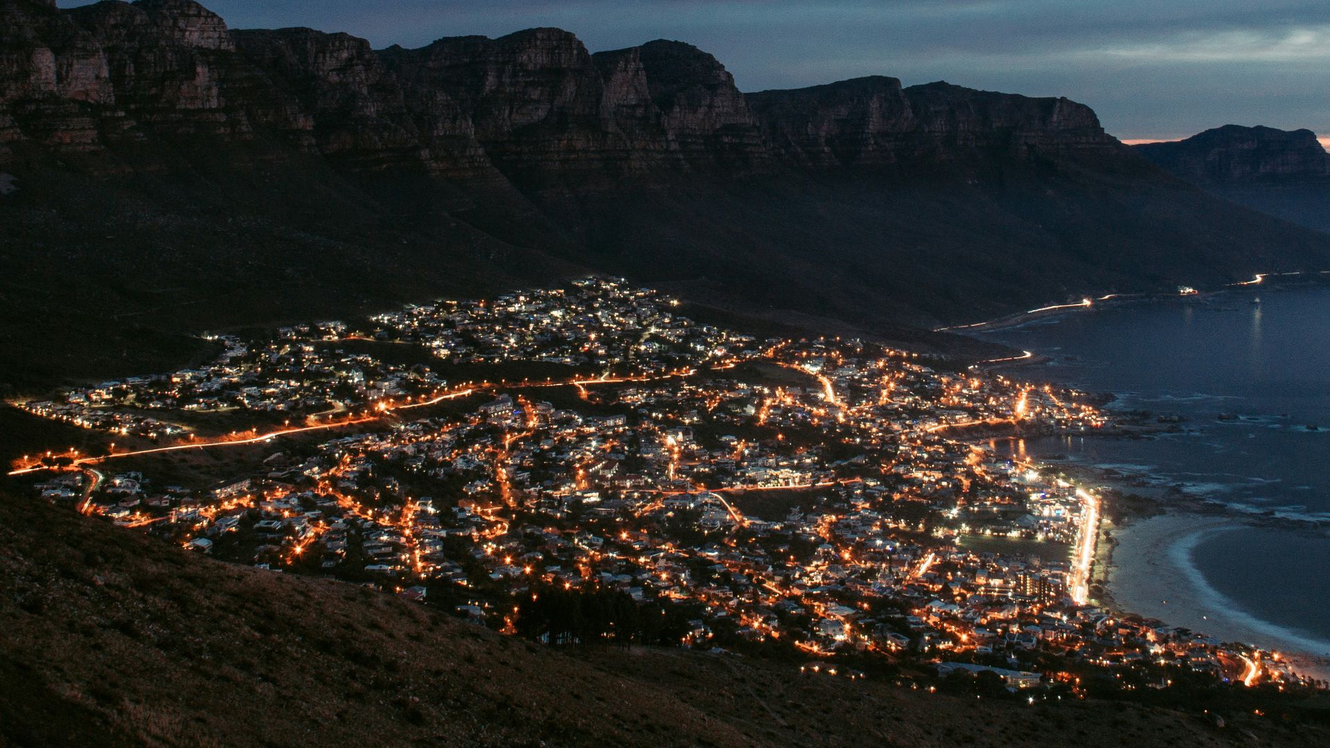 city near mountain during night time