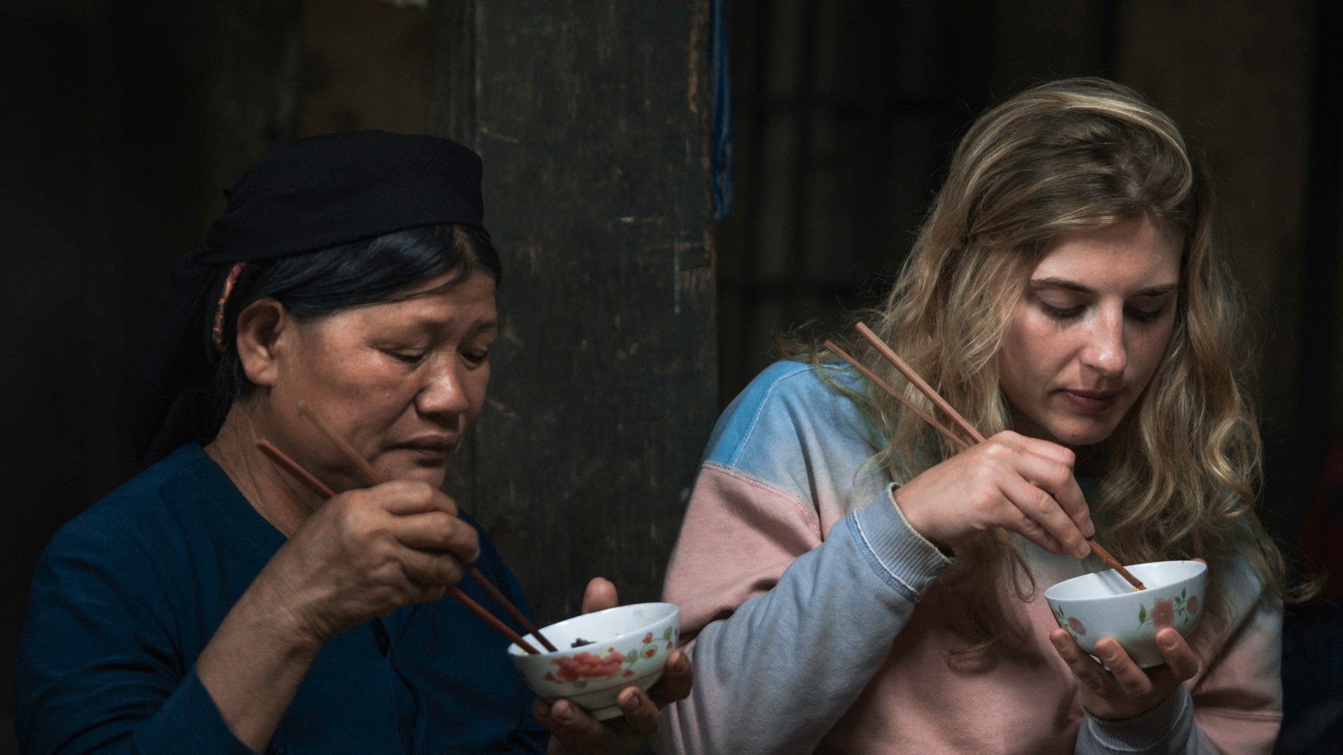 two women using chopsticks for eating