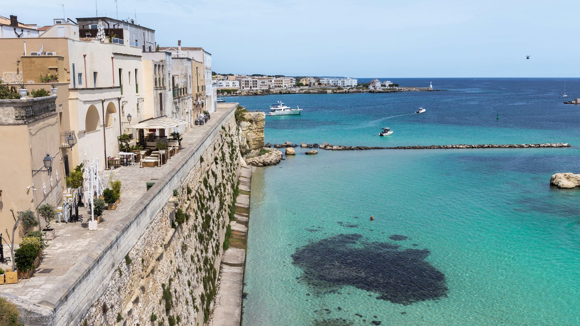 people are swimming in the clear blue water