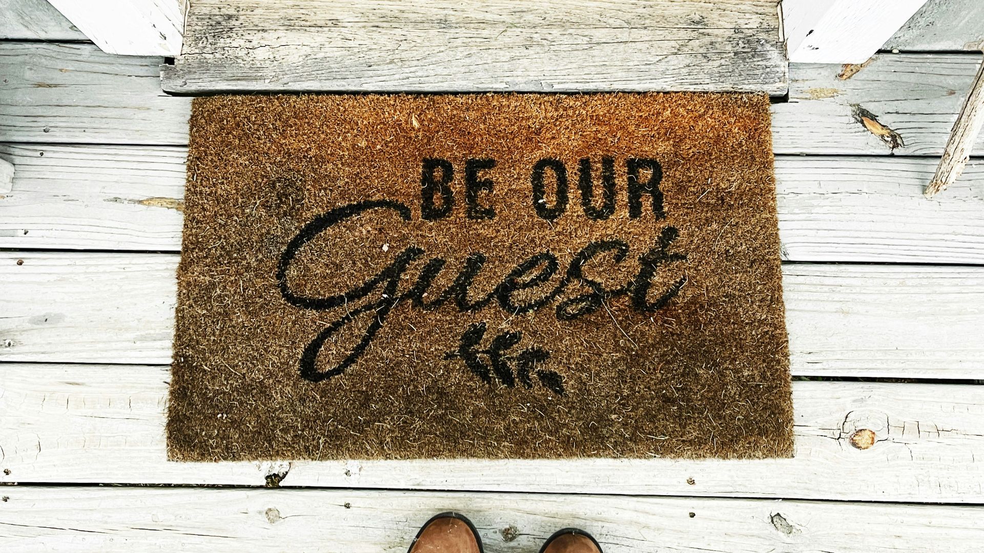 a person's feet on a wooden surface with a sign
