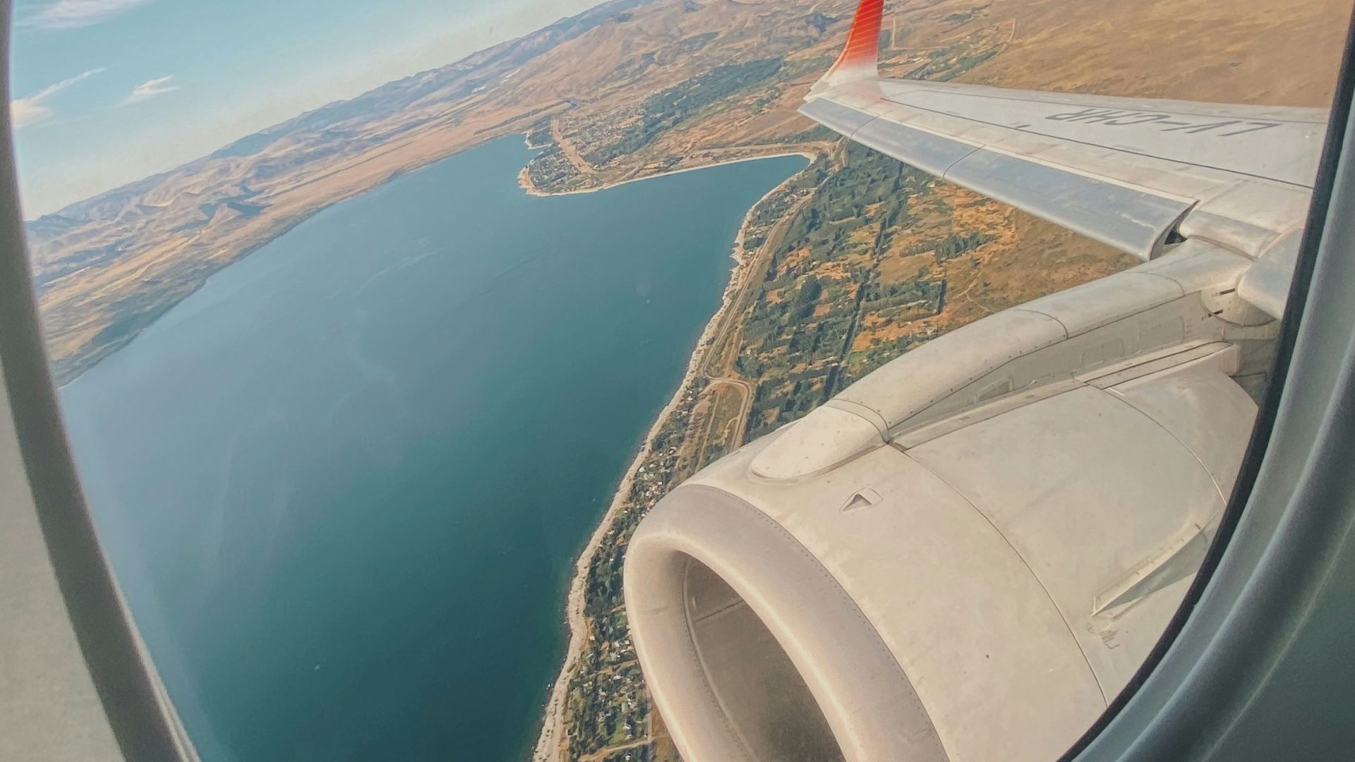 white and red airplane wing over the sea during daytime