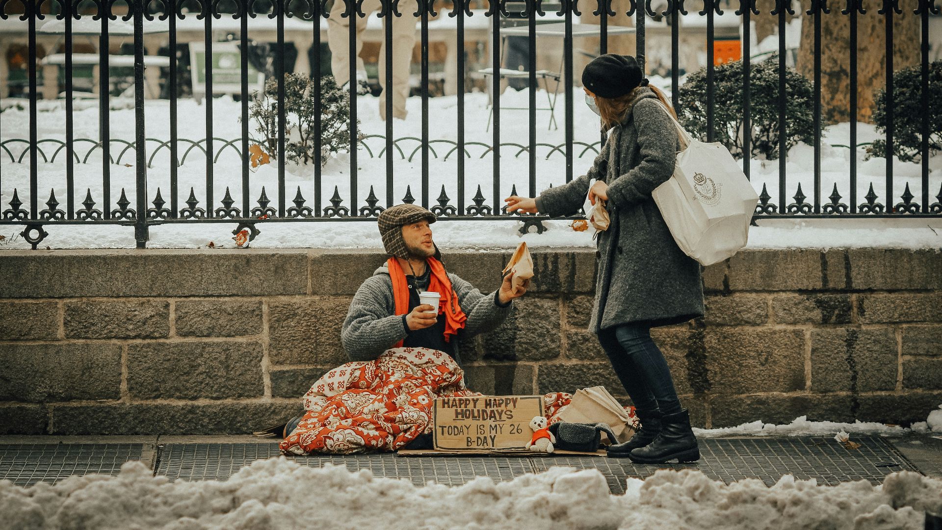 man in black jacket and black pants sitting on white snow covered ground during daytime