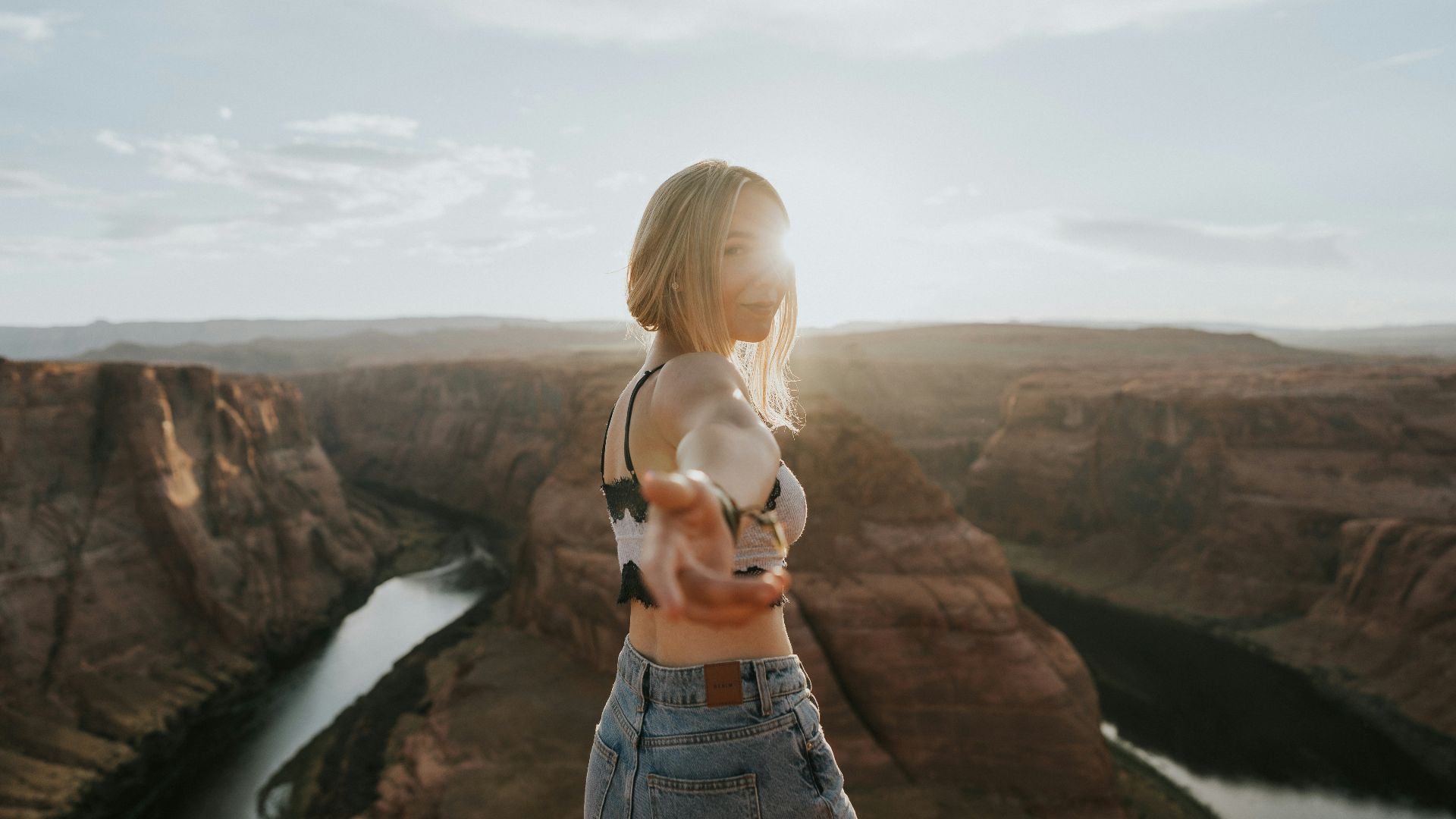woman in blue denim shorts standing on cliff during daytime