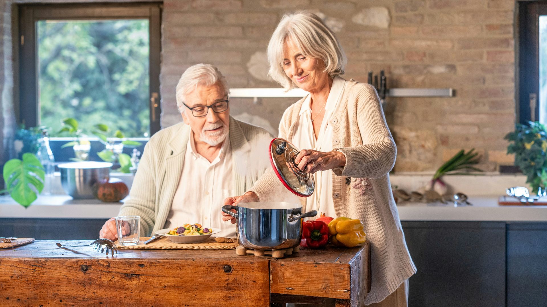 Elderly couple cooking together in a modern kitchen.