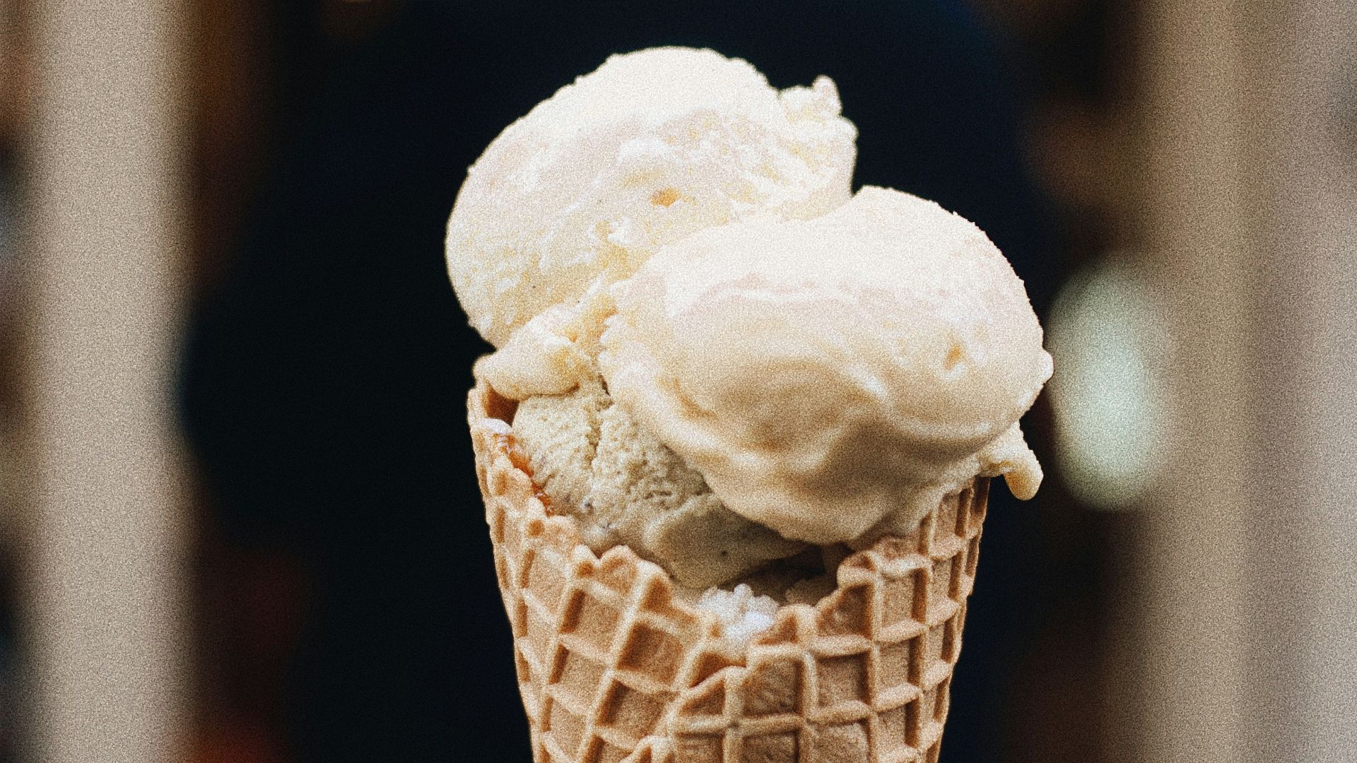 a hand holding a cone of ice cream