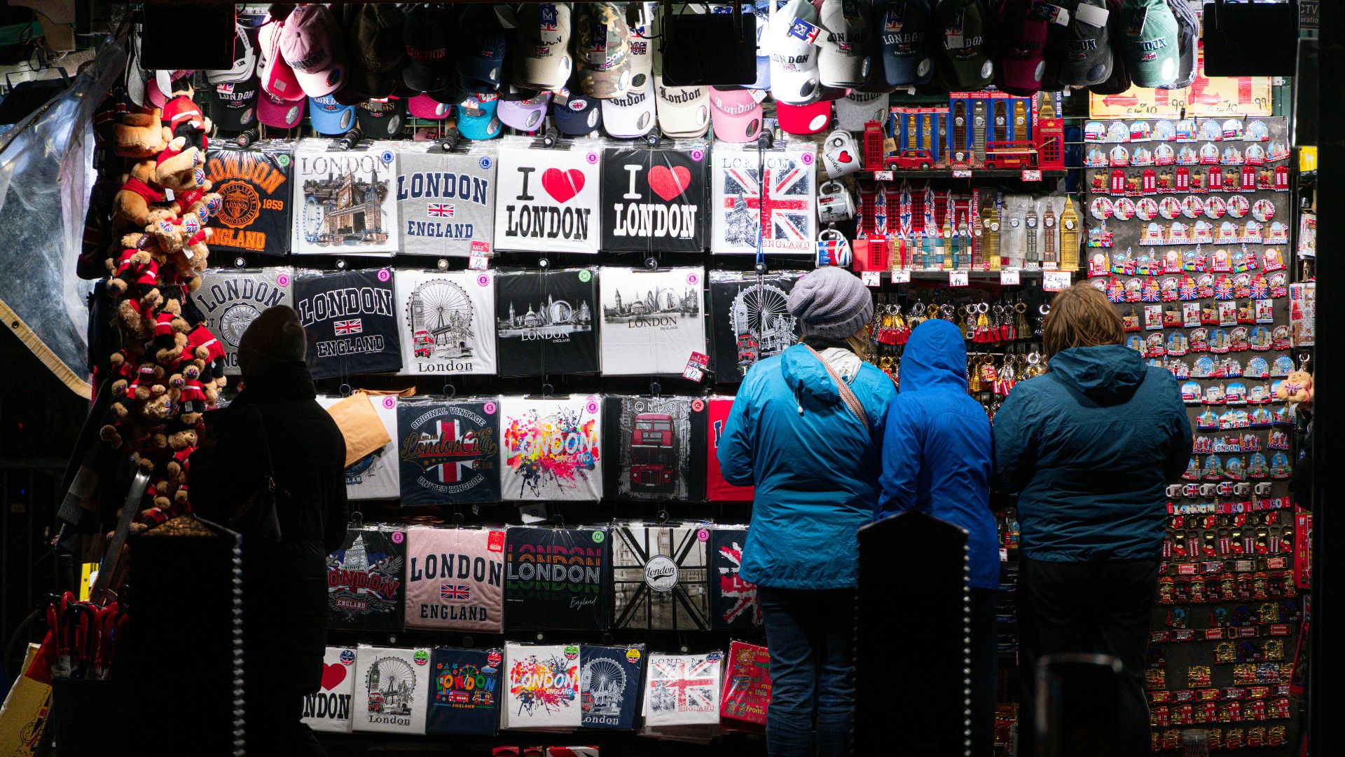 People browsing souvenirs at a london market stall.