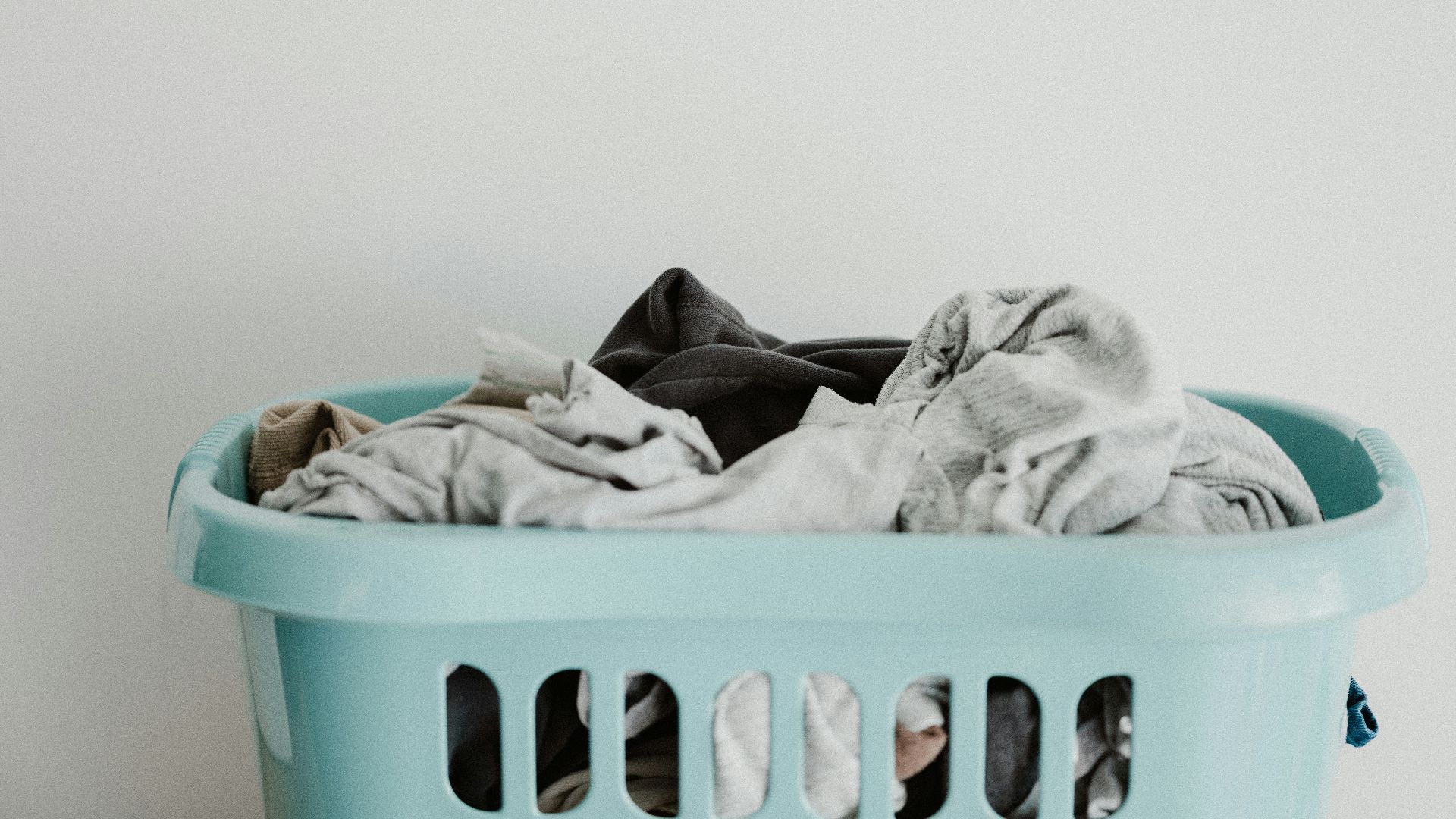 white textile on blue plastic laundry basket