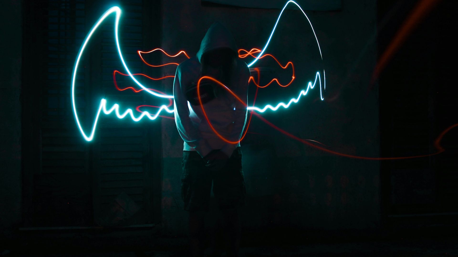 man in black jacket standing in front of neon light signage