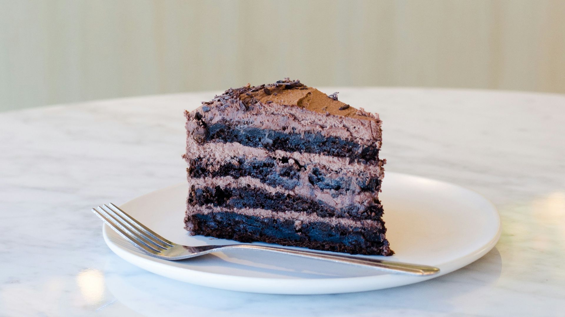 sliced chocolate cake beside fork on plate