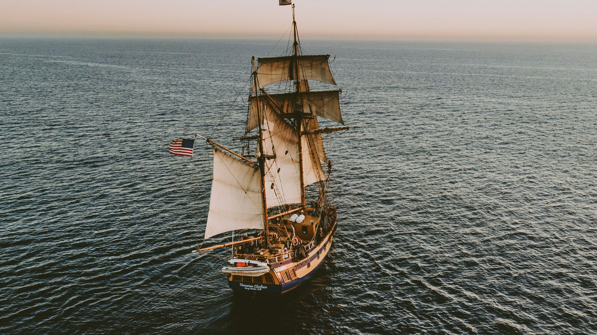 brown sailboat in beach under white sky
