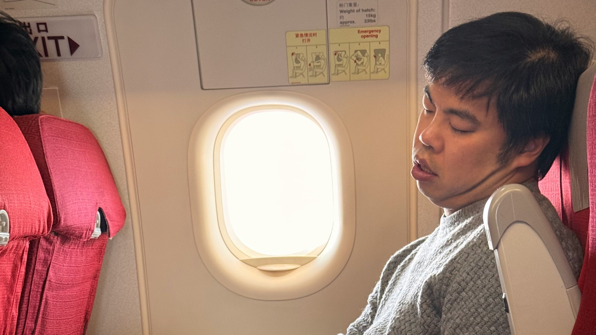 Man sleeping on airplane with laptop on tray