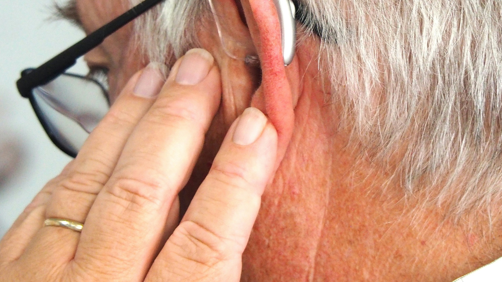A man wearing glasses and a pair of headphones