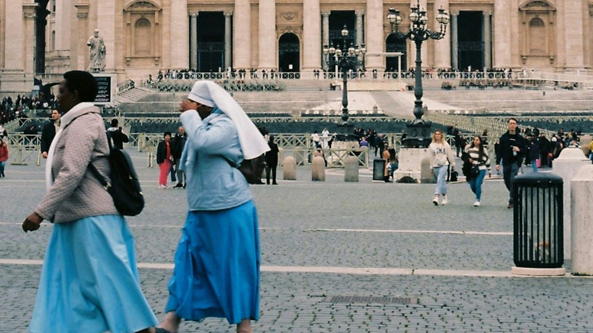 two women walking in front of a large building