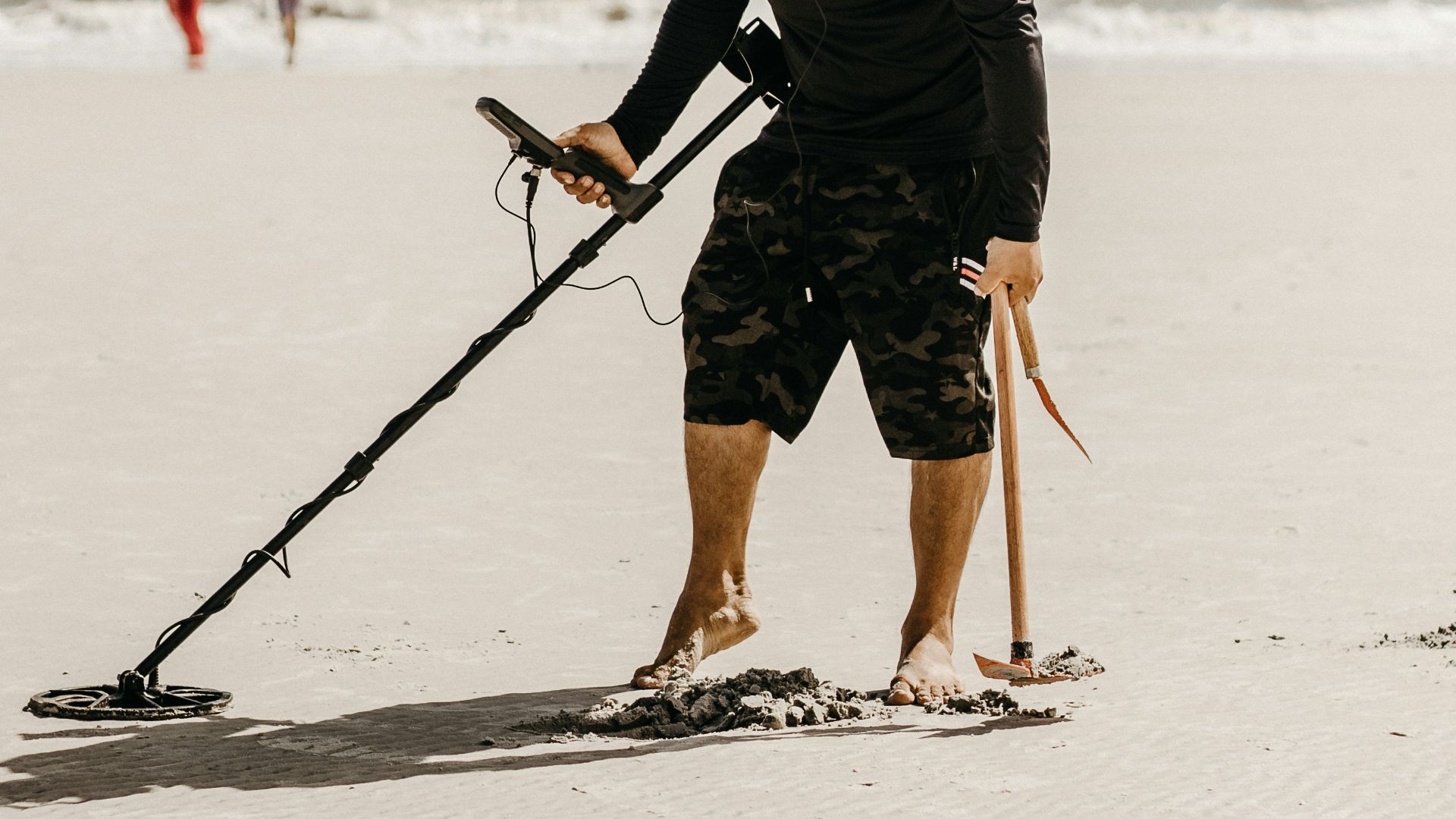 a man holding a stick on the beach