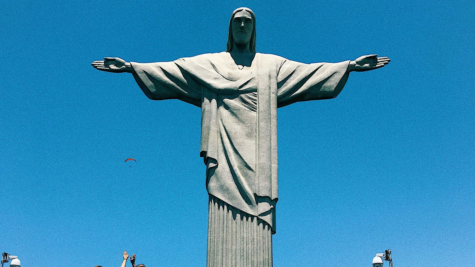 people gathering in a park with statue of liberty in the distance